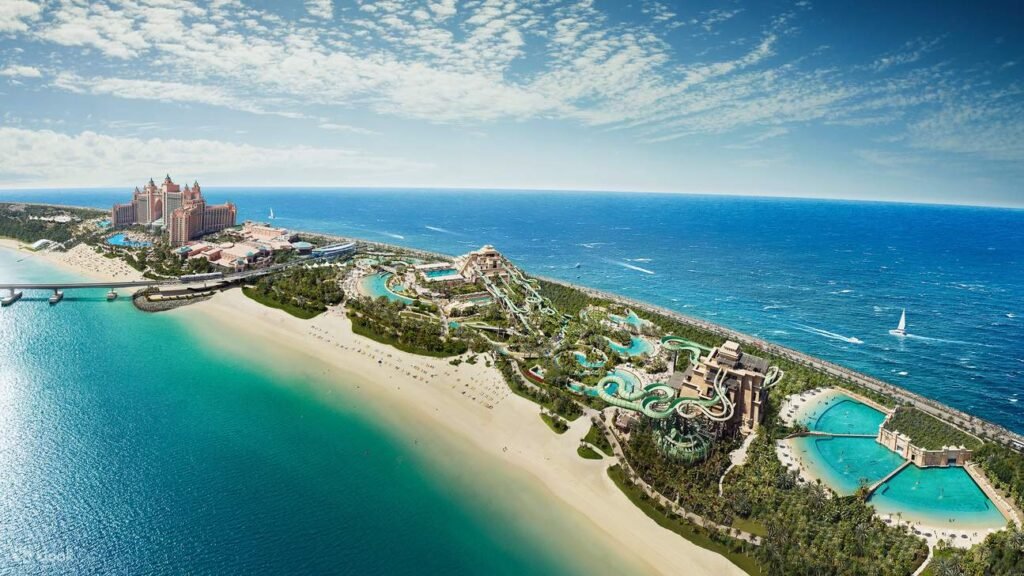 Aerial view of a coastal resort with multiple pools and a sprawling beachscape against a blue ocean backdrop.