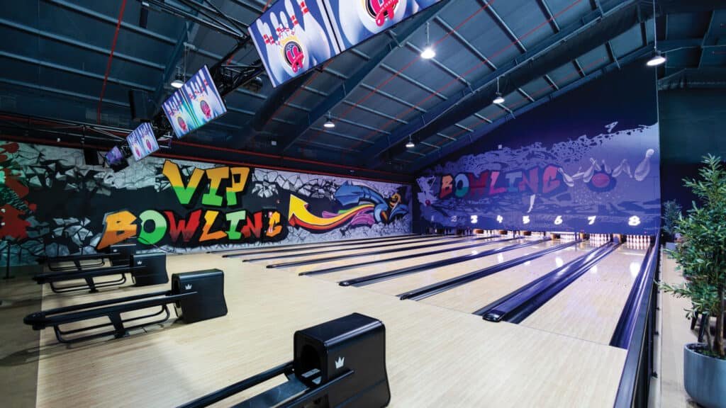 Bowling alley with colorful graffiti walls and multiple lanes; "VIP Bowling" text visible.