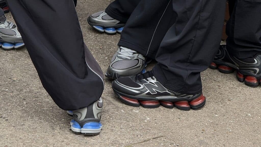 People wearing sports shoes with distinctive spring-like soles, standing on a concrete surface.