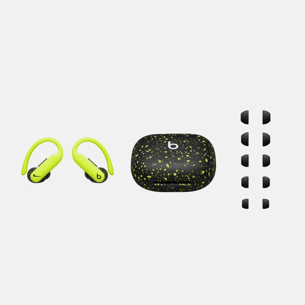 Wireless earbuds with neon green ear hooks, a black charging case with yellow speckles, and five sets of black ear tips.