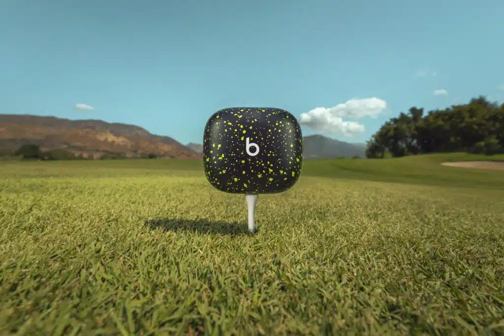 A black and speckled golf tee cap with a 