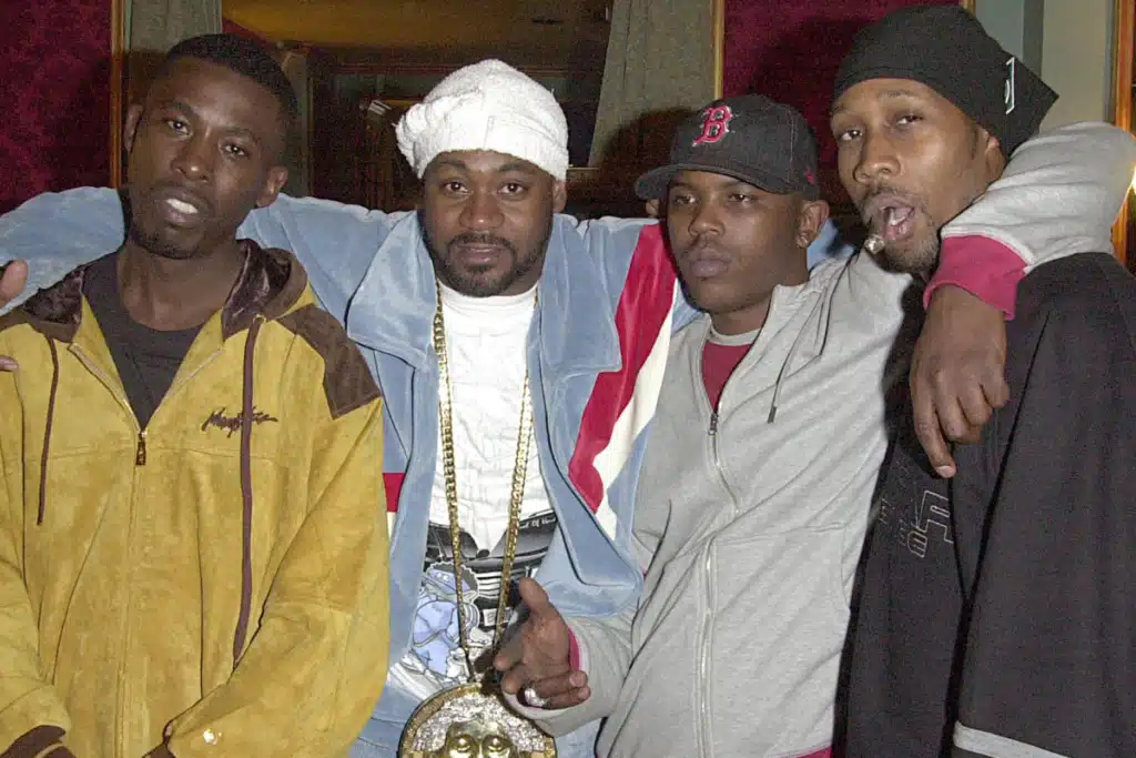 GZA, Ghostface Killa, Oliver 'Power' Grant, and RZA pose together in casual clothing, with one wearing a large medallion.