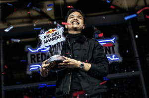A person holding a Red Bull Basement trophy, smiling, with confetti falling around them.