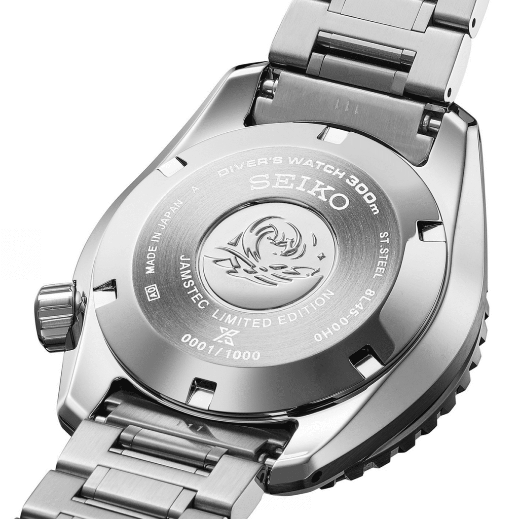The back of a Seiko Prospex Marinemaster diver's watch, featuring engraved text, a serial number, and a shark emblem.