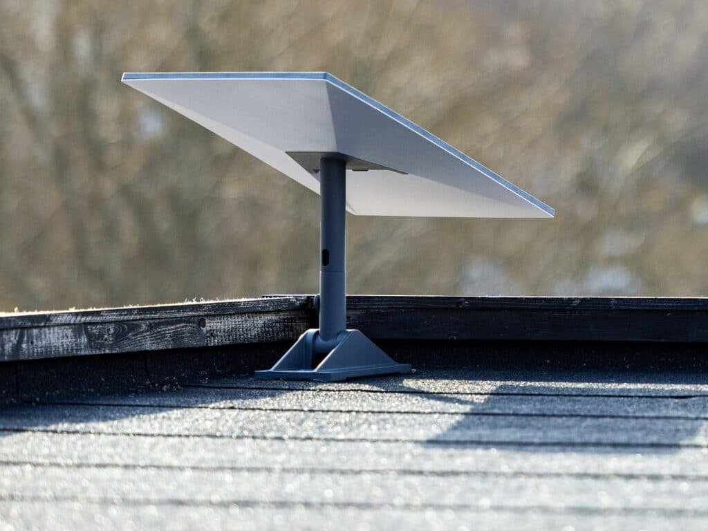 A Starlink UAE satellite dish mounted on a rooftop with a blurred natural background.