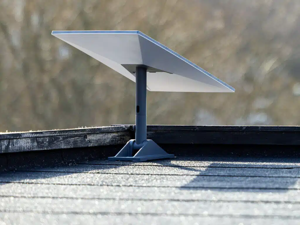 A Starlink UAE satellite dish mounted on a rooftop with a blurred natural background.