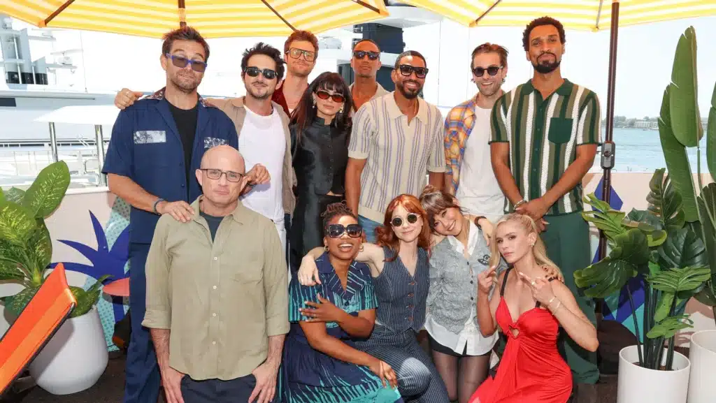 The cast of The Boys Season 5 is posing together under a shaded area, with a relaxed, festive vibe.