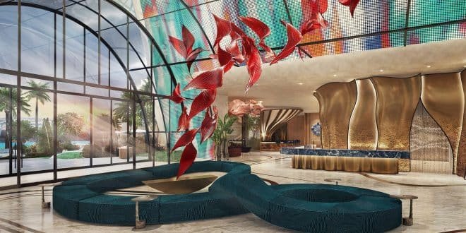 A modern hotel lobby with a curving seating area, red abstract sculpture, and large arched windows with a view of palm trees.