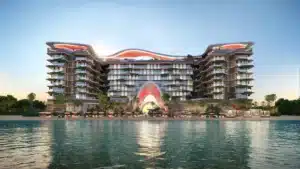 A modern beachfront resort with a unique wavy architectural design, featuring balconies and a sunset backdrop.