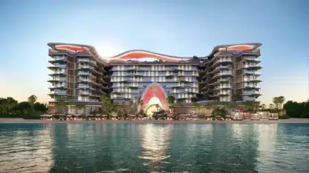 A modern beachfront resort with a unique wavy architectural design, featuring balconies and a sunset backdrop.