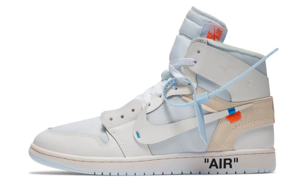 A white Air Jordan 1 'Alaska' high-top sneaker with blue and beige accents, featuring a deconstructed design and "AIR" text on the sole.