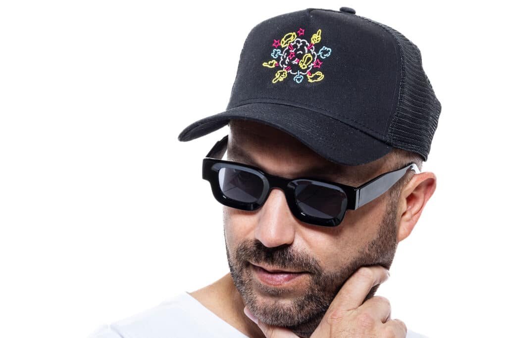 Nic Fanciulli wearing sunglasses and a black cap with a colorful floral design.