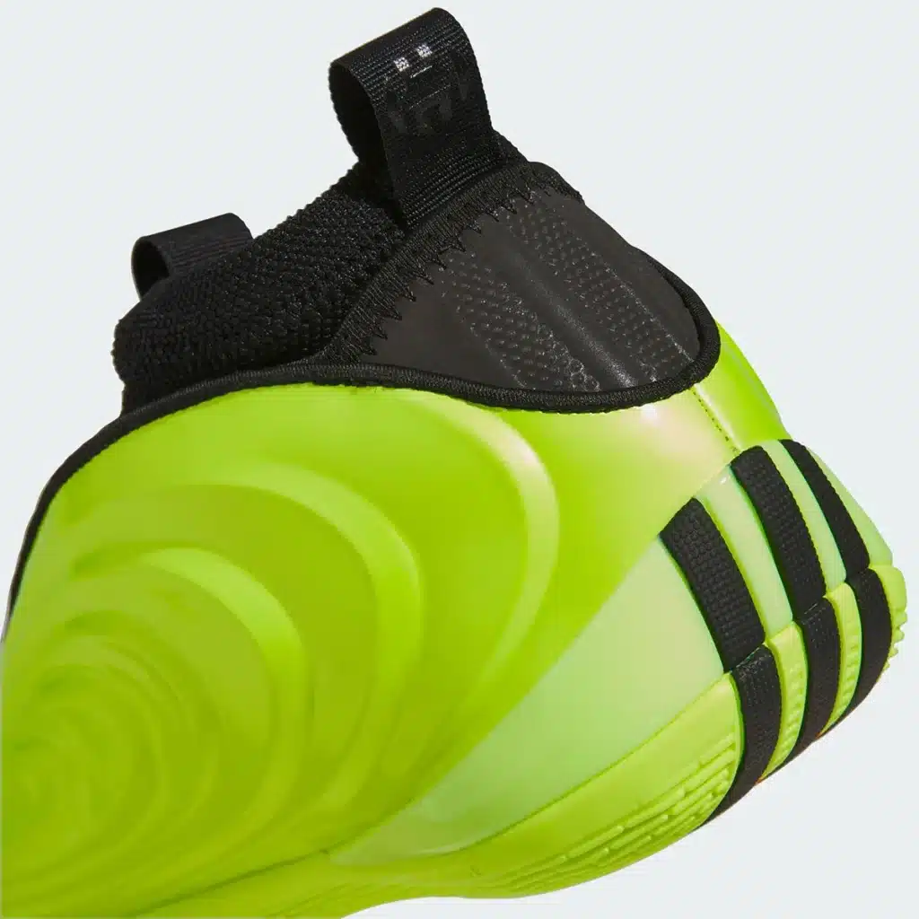 A bright green sneaker with black accents and a unique wave-like pattern on the side and heel.