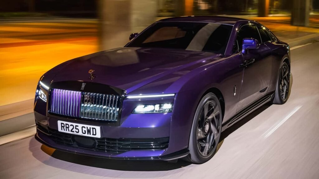 A sleek purple Rolls-Royce Black Badge luxury car with a distinctive grille and black trim, driving on a road at night.