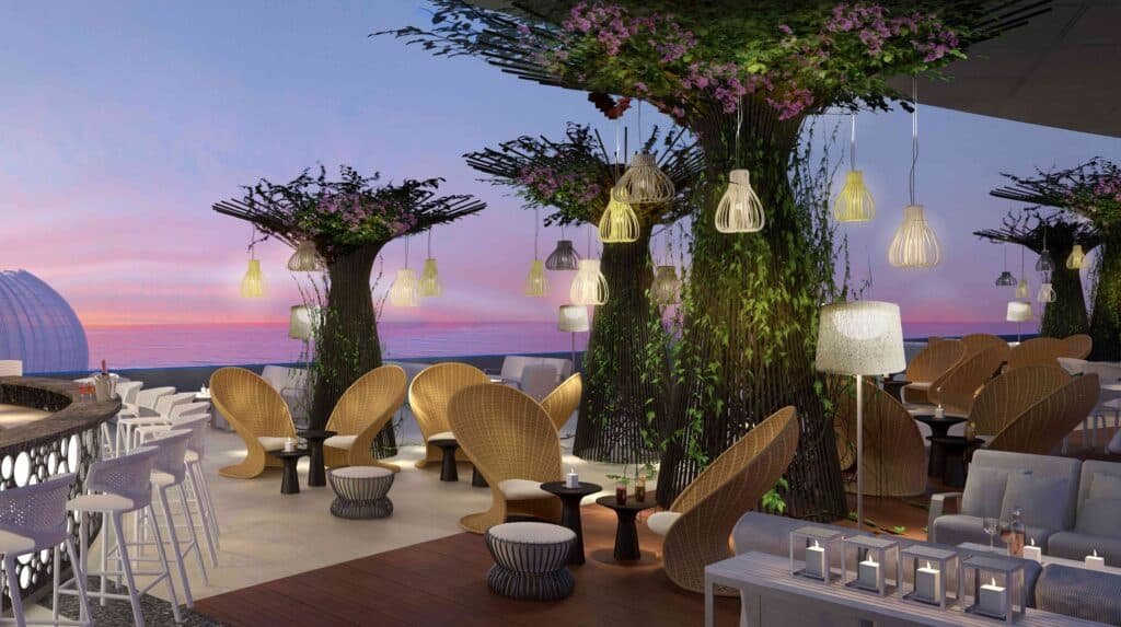 Best Seafood Restaurants on Abu Dhabi Corniche: Rooftop lounge with wicker chairs, tables, and trees adorned with hanging lights, set against a sunset sky.