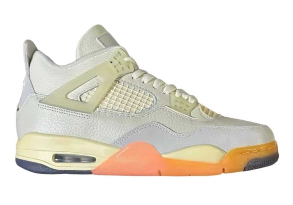 A stylish sneaker featuring a mix of white, cream, and orange tones with a visible air unit and textured leather details.