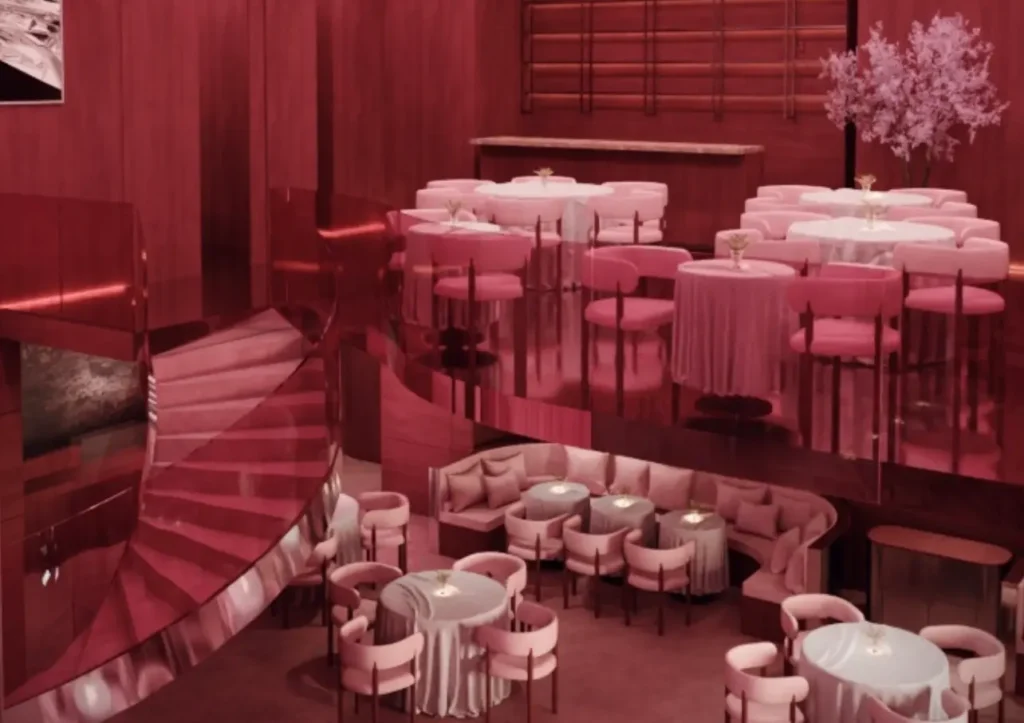 A chic, modern restaurant interior with pink seating and tables on two levels, featuring a spiral staircase and ambient lighting.