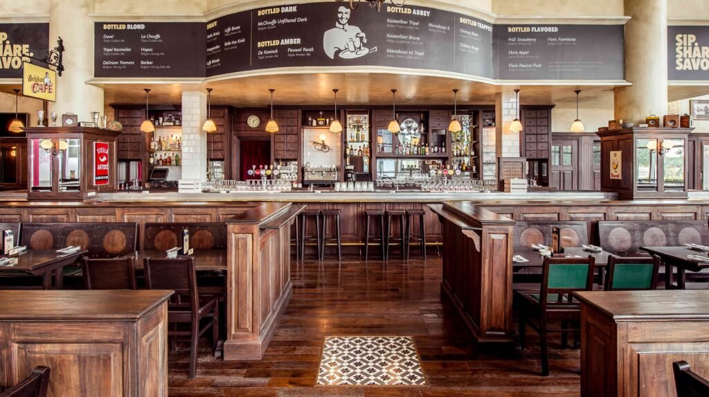 A spacious, rustic-style bar with wooden decor, leather seating, and a long counter displaying various bottles.