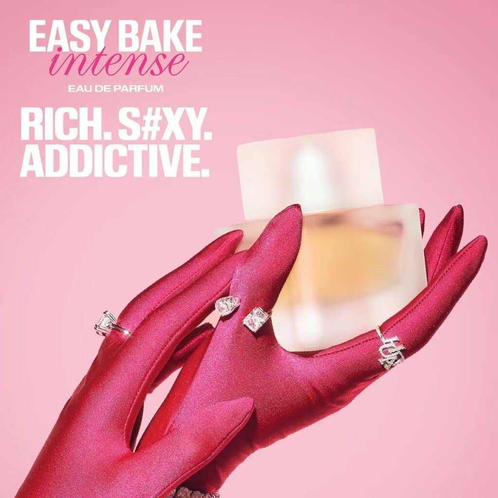 Pink perfume ad with magenta-gloved hands holding a frosted bottle and bold text reading Easy Bake Intense Eau de Parfum
