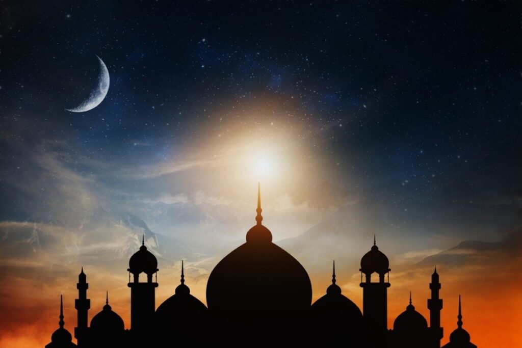 Silhouette of a mosque under a starry sky with a crescent moon and a glowing sunset.
