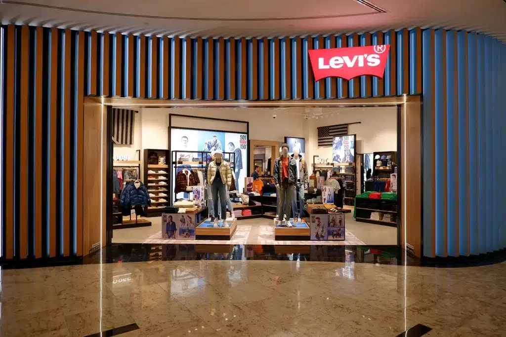 Storefront of a Levi's clothing store with mannequins in denim outfits displayed at the entrance.