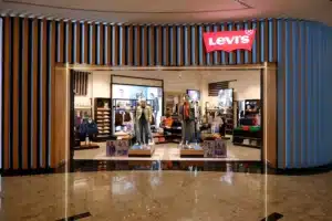 Storefront of a Levi's clothing store with mannequins in denim outfits displayed at the entrance.