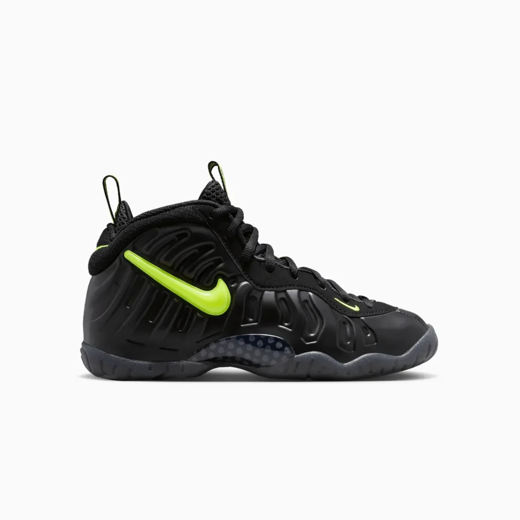 Black Nike Air Foamposite Pro sneaker with a wavy textured design, bright green swoosh logo, and green accents on the tongue and heel tabs.