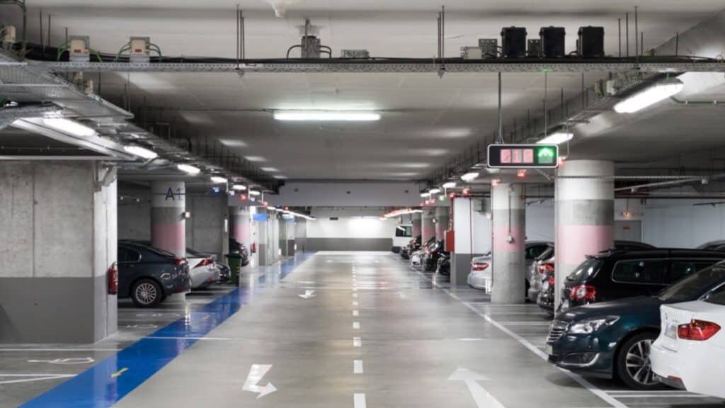Parkin Launches AI-Powered Parking at Dubai Mall: Underground parking garage with cars parked along both sides and a pathway marked with directional arrows.