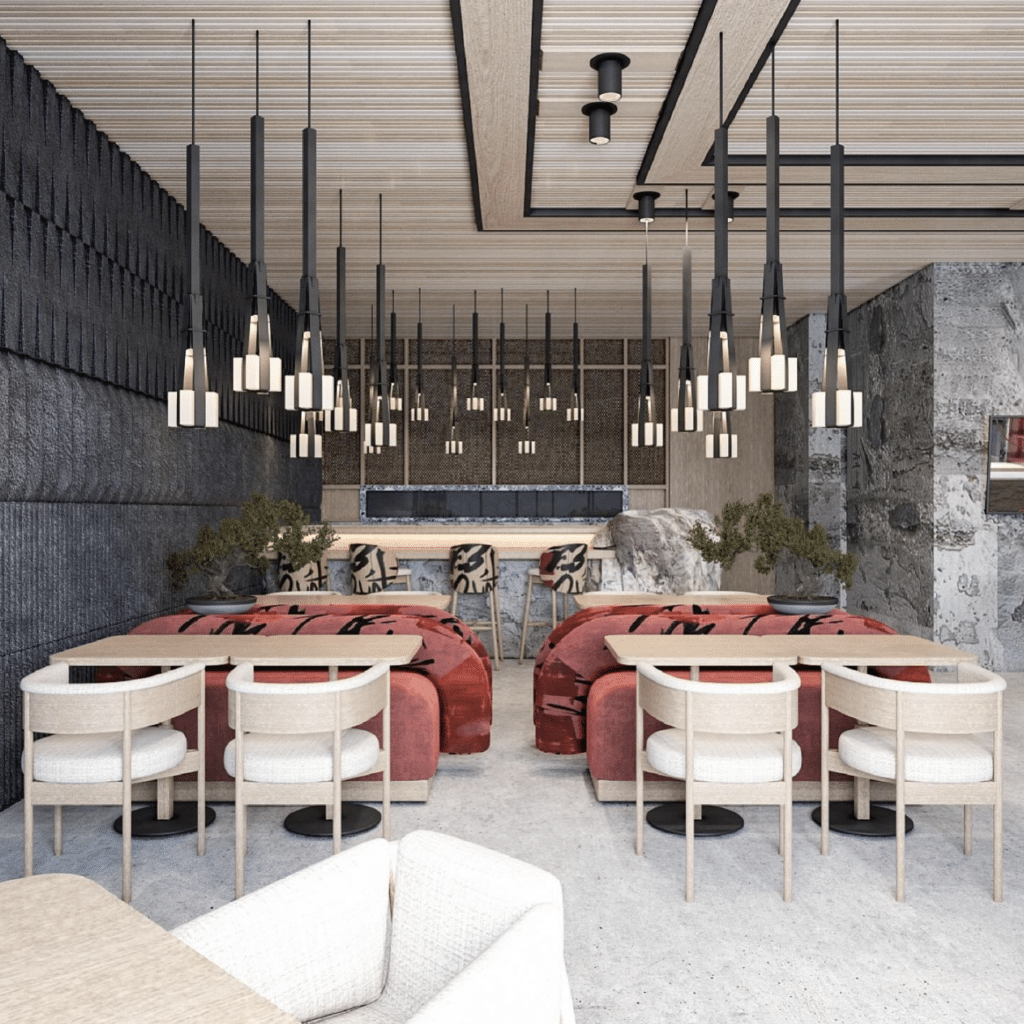 Modern dining area with red cushioned seating, white chairs, and sleek black pendant lighting against a textured wall background.