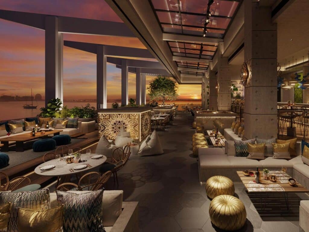 Luxurious rooftop restaurant with lounge seating and a sunset view over the water