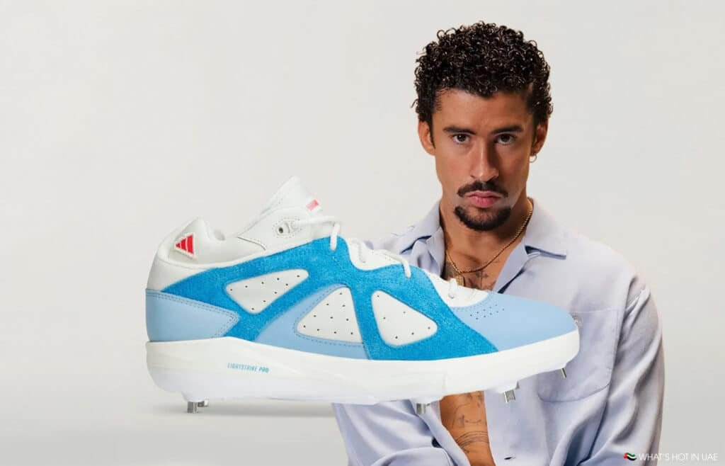Man holding a large blue-and-white athletic shoe against a plain background