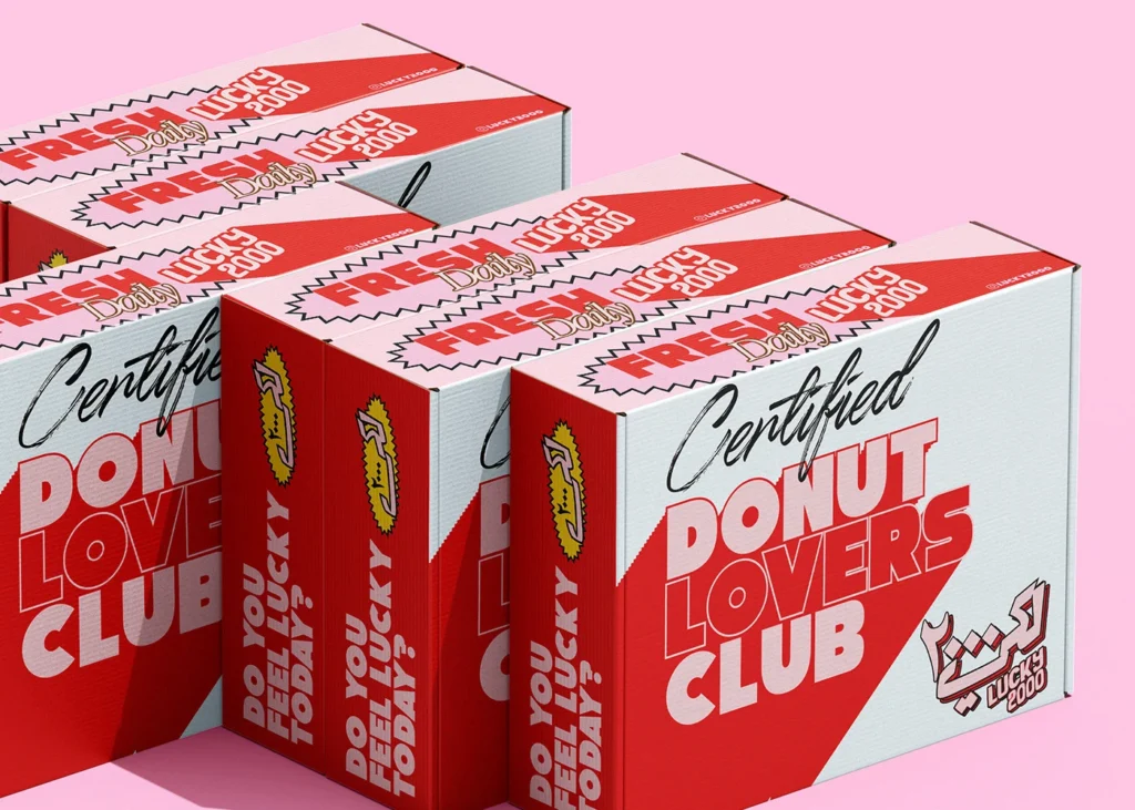 Red and white Lucky 2000 donut boxes on a pink background, labeled Certified Donut Lovers Club