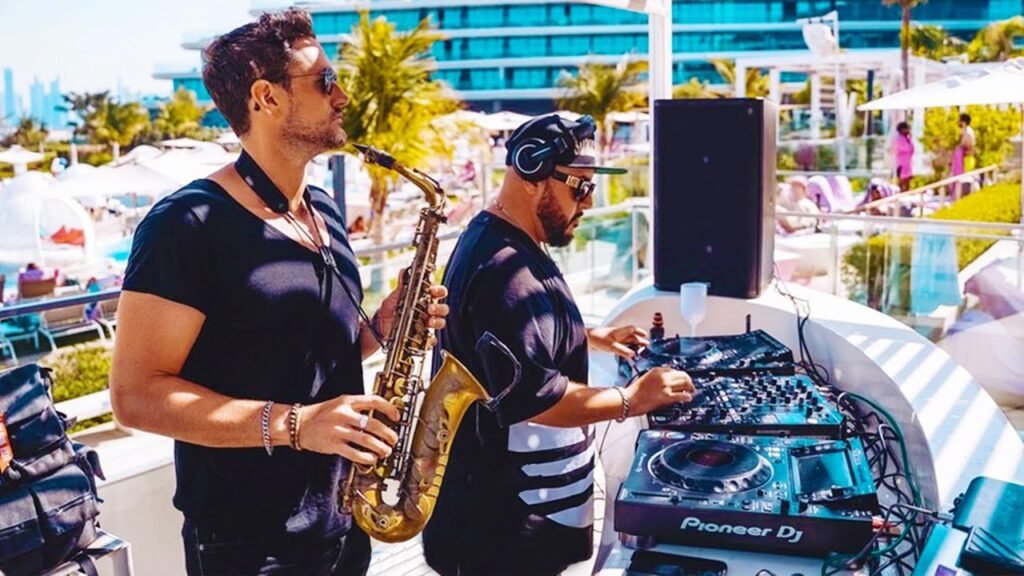 Matt West and Smokingroove perform at Wet Deck, W Dubai The Palm, one holding a saxophone and the other mixing music
