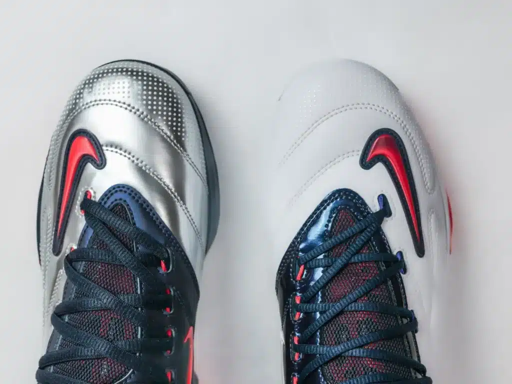Top view of two Nike bParis Saint-Germain x Nike KD 6 asketball shoes, one silver and one white, with dark laces and red accents