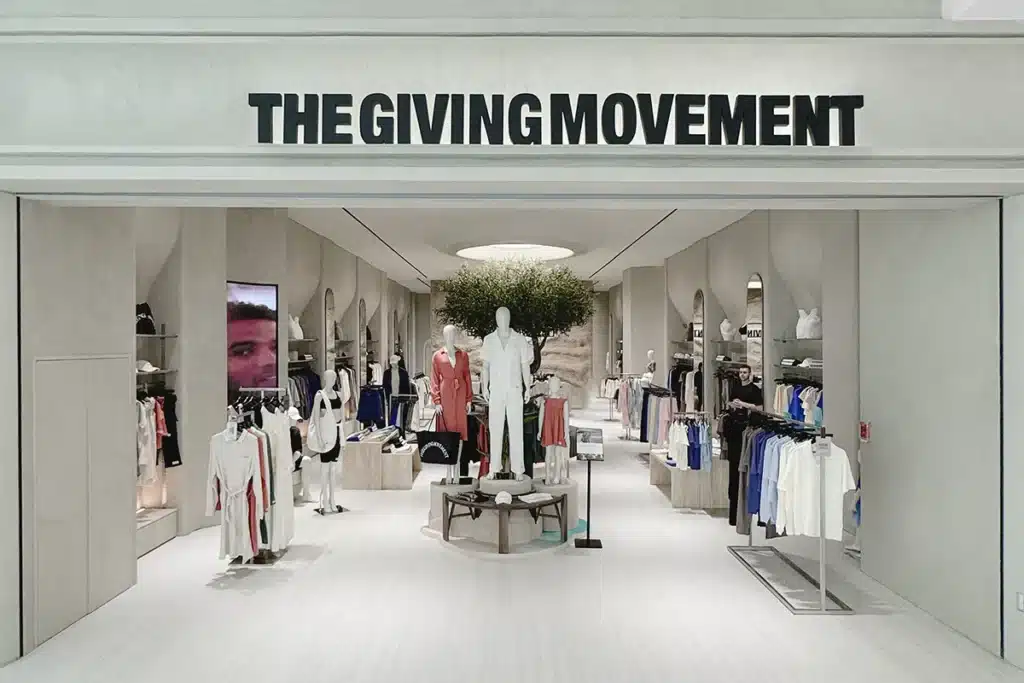Clothing boutique with mannequins and racks, labeled THE GIVING MOVEMENT above the entrance