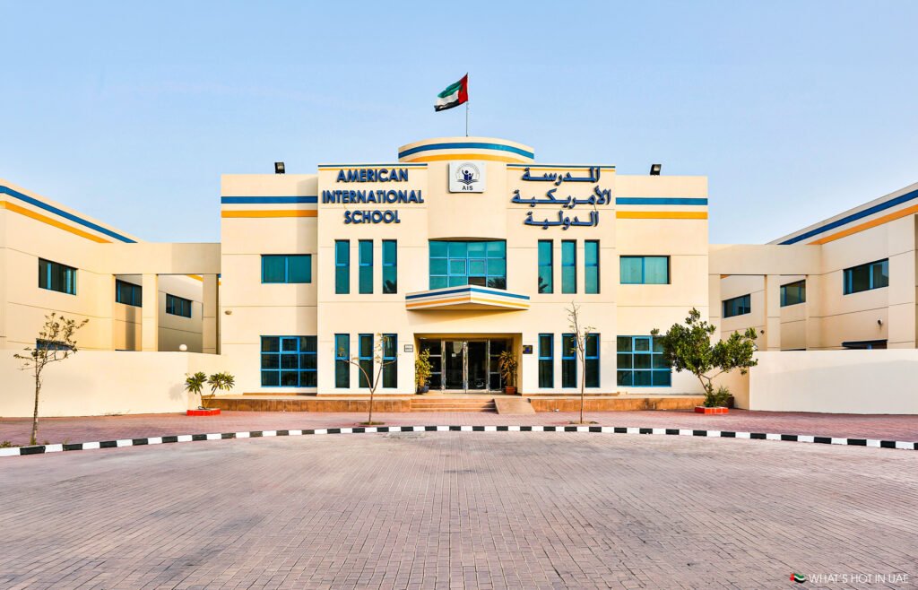 Dubai changes July 2026: American International School building with UAE flag and Arabic signage on the facade