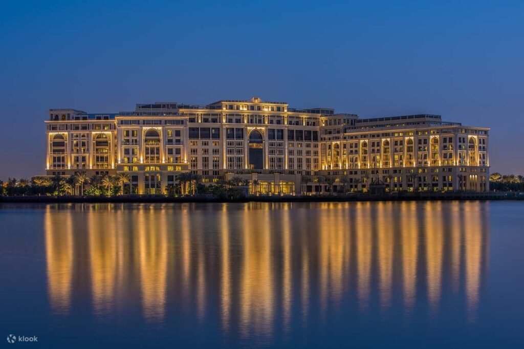 Illuminated waterfront resort building at dusk, reflected in calm water