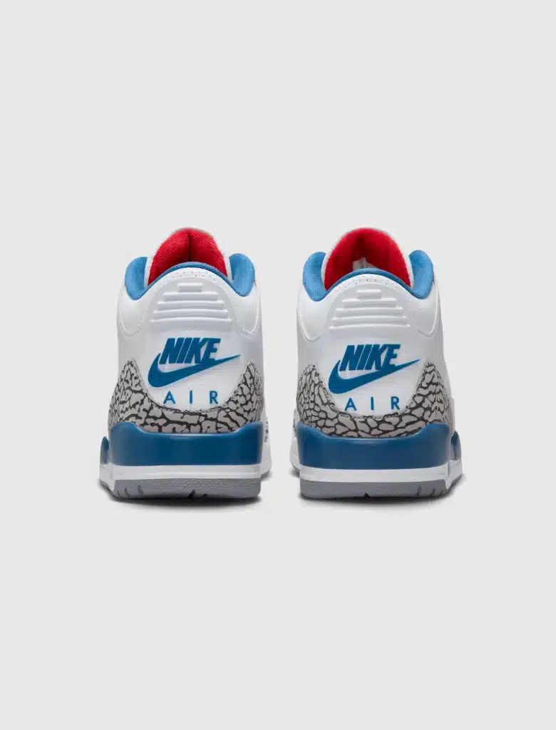Pair of white Nike Air sneakers shown from the back, with blue and red accents and gray elephant print heels