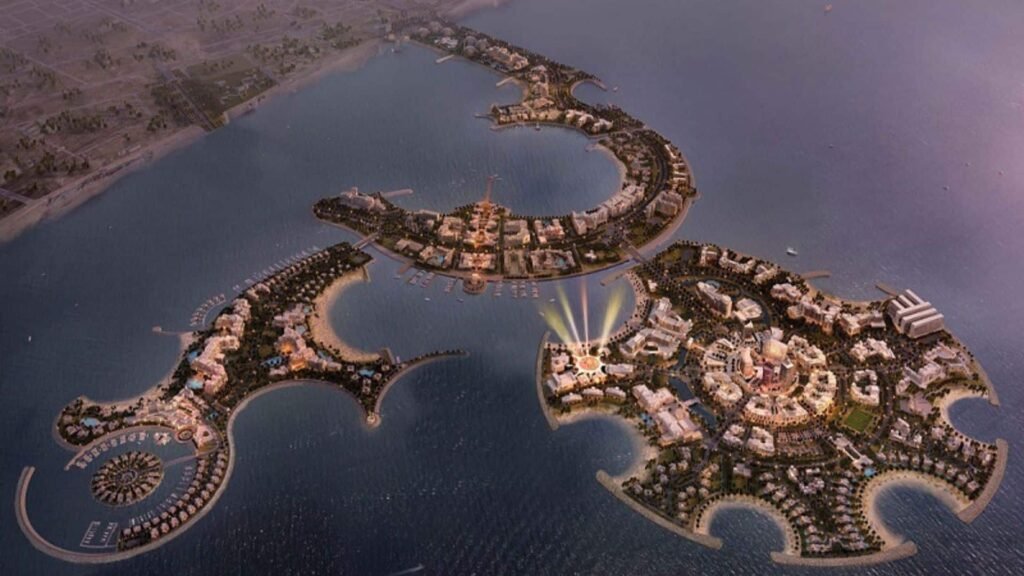 Aerial rendering of Al Marjan Island with curved peninsulas, beaches, marinas, and clustered buildings in the sea