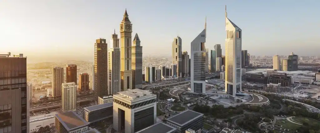 Sunlit DIFC skyline with tall modern skyscrapers and a large roundabout below at dusk
