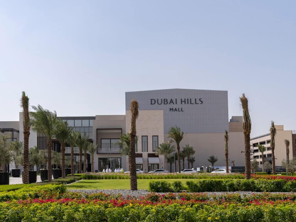 Dubai Hills Mall exterior with palm trees and landscaped flower beds
