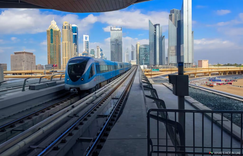 Blue Dubai Metro train on elevated tracks with a modern city skyline in the background