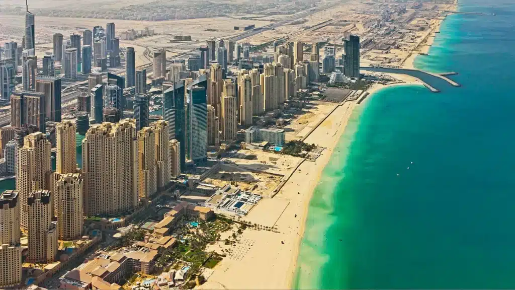 Aerial view of JBR (Jumeirah Beach Residence) skyline beside a long sandy beach and turquoise sea