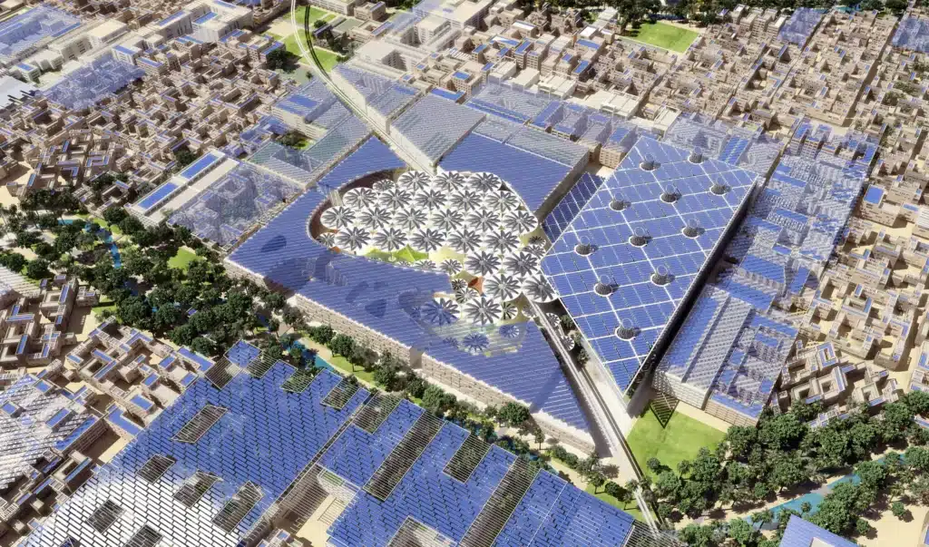 Aerial view of Masdar City covered in blue solar panels with a central green plaza and wind turbine-like structures