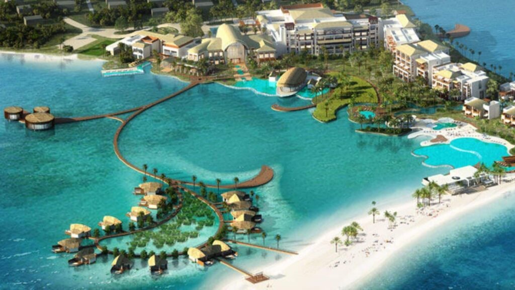 Aerial view of Al Majaz with overwater villas, beaches, pools, and boardwalks on turquoise water