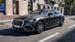 Dark Mercedes-Benz sedan driving on a city street