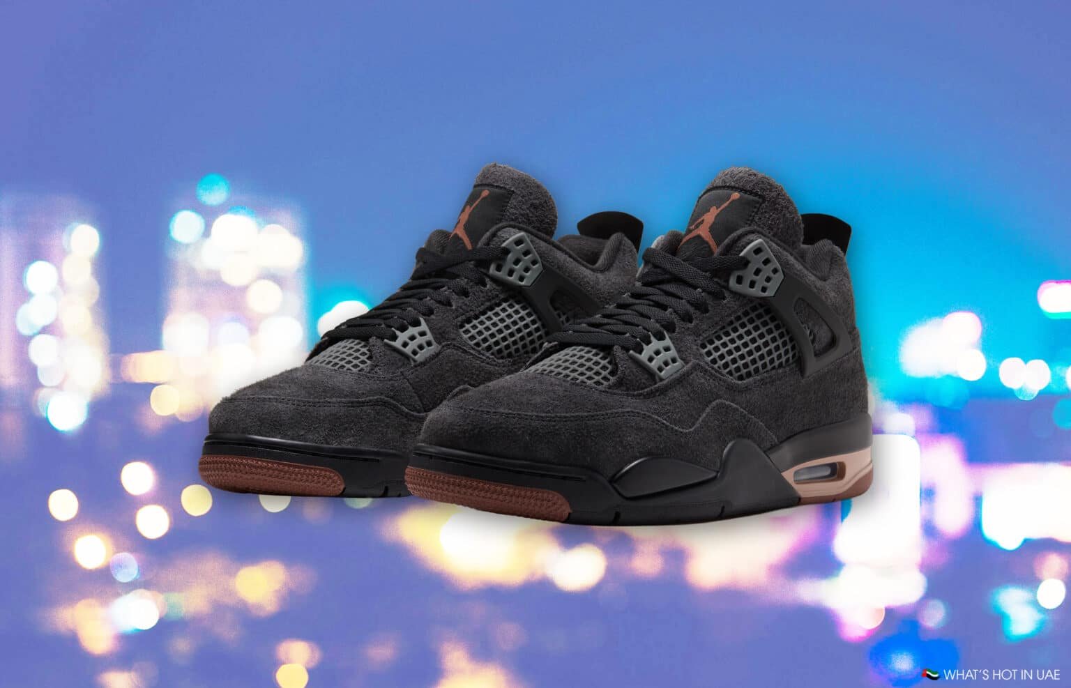 Pair of black and gray high-top sneakers with brown soles against a colorful blurred background