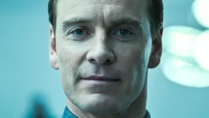 Close-up portrait of a serious-looking man with blue eyes, lit by cool blue light