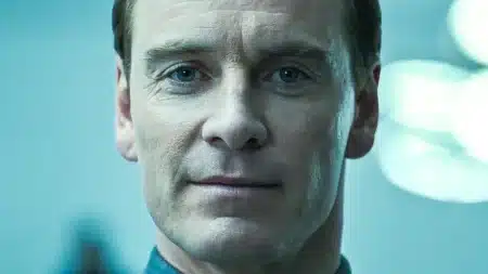 Close-up portrait of a serious-looking man with blue eyes, lit by cool blue light