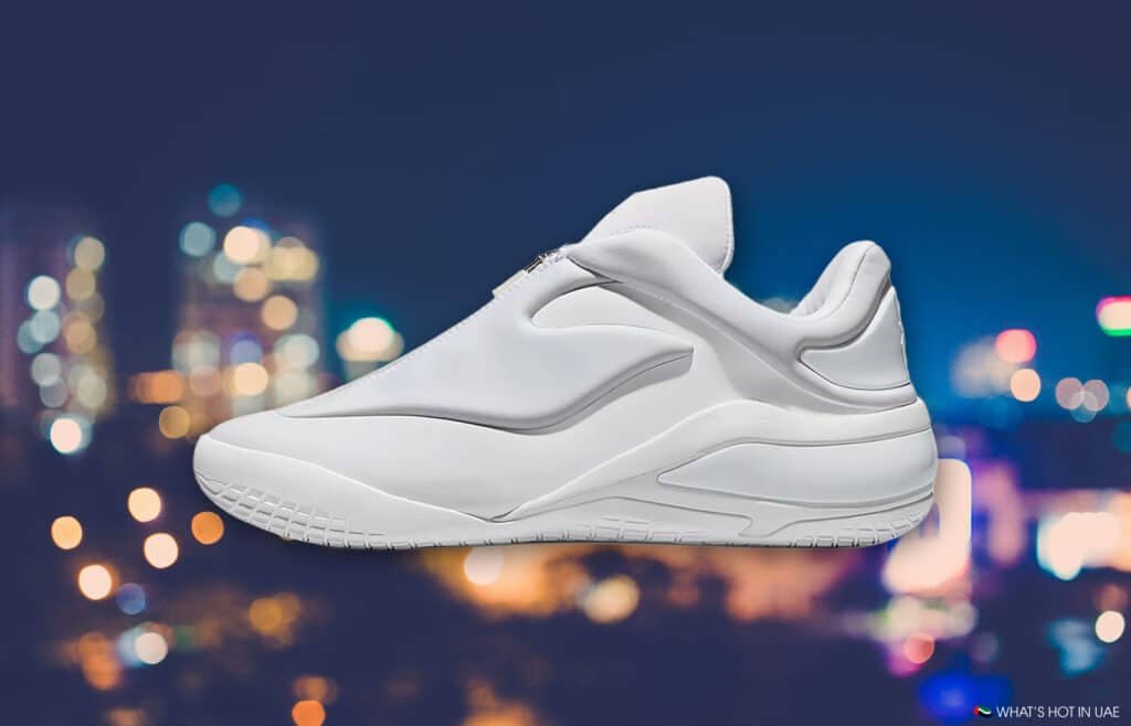 White athletic sneaker against a blurred city-light background